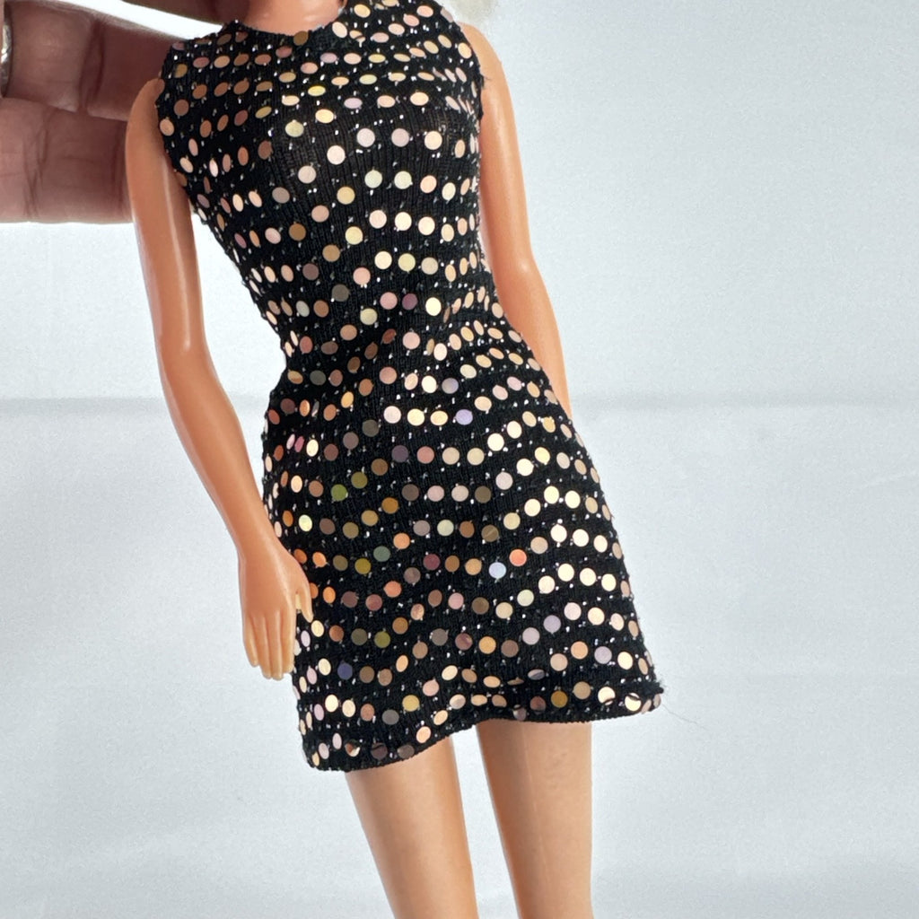 Mattel blonde Barbie doll with Twist 'N Turn body wearing a black sequin dress and gold crown