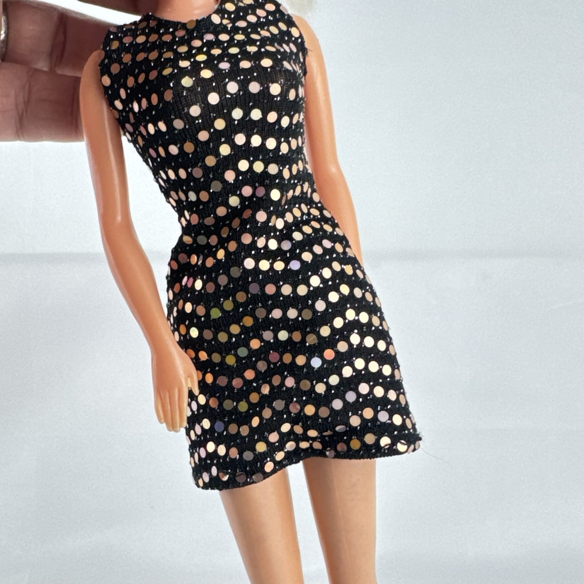 Mattel blonde Barbie doll with Twist 'N Turn body wearing a black sequin dress and gold crown