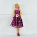 Mattel Barbie doll with blonde hair wearing a pink and purple metallic diamond dress with pink high heels