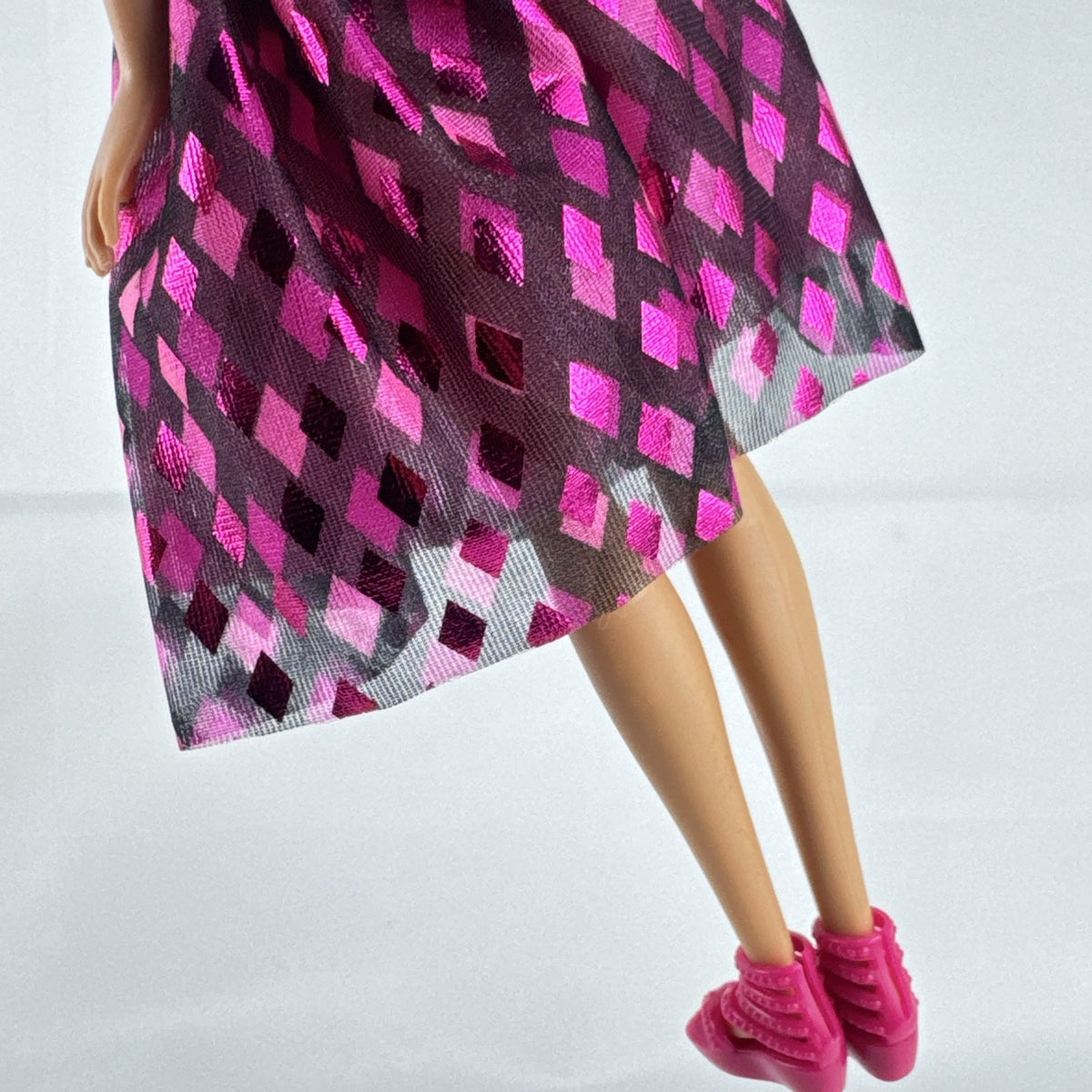 Mattel Barbie doll with blonde hair wearing a pink and purple metallic diamond dress with pink high heels