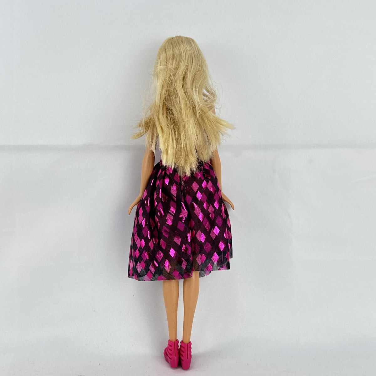 Mattel Barbie doll with blonde hair wearing a pink and purple metallic diamond dress with pink high heels
