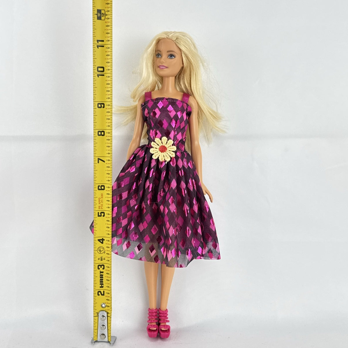 Mattel Barbie doll with blonde hair wearing a pink and purple metallic diamond dress with pink high heels