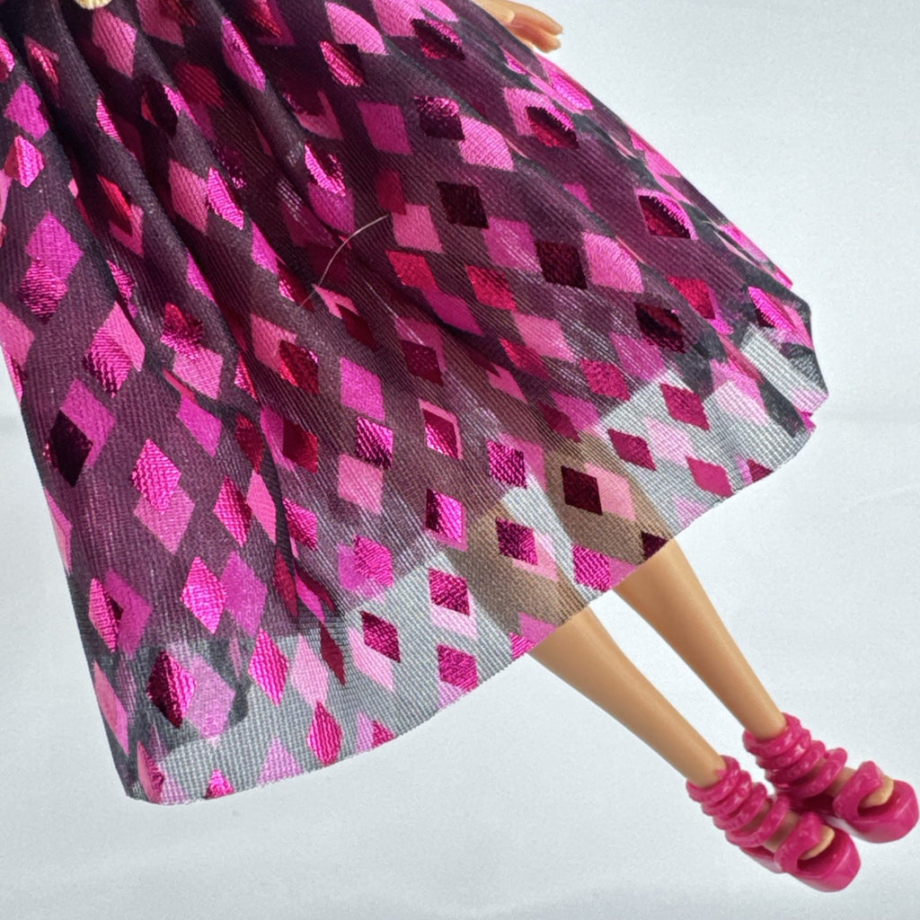 Mattel Barbie doll with blonde hair wearing a pink and purple metallic diamond dress with pink high heels