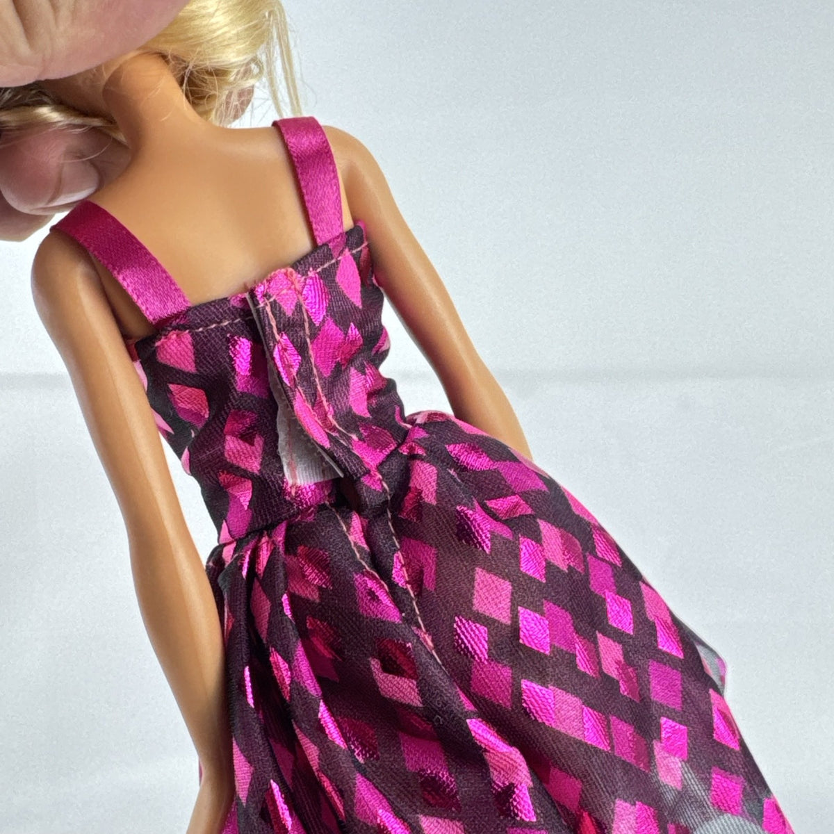 Mattel Barbie doll with blonde hair wearing a pink and purple metallic diamond dress with pink high heels