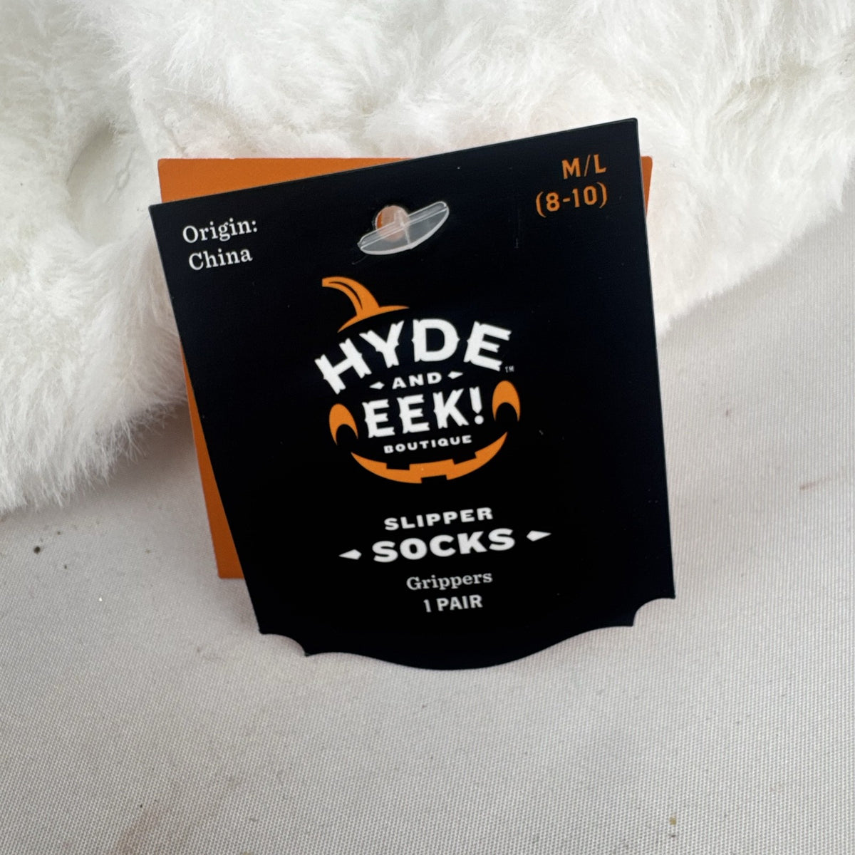 Hyde & EEK! Boutique ivory faux-fur slipper socks with black bat silhouettes and non-slip treads in women's size M/L.