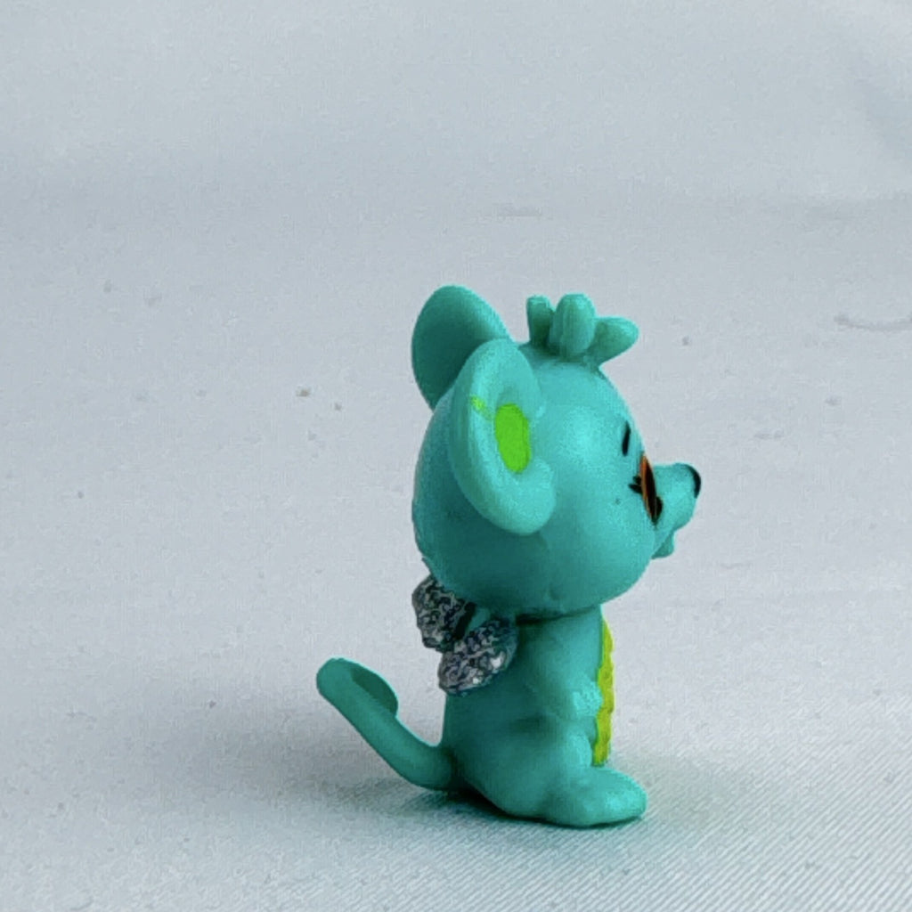 Spin Master Hatchimals CollEGGtibles mini figure in teal and lime green with silver glitter wings.