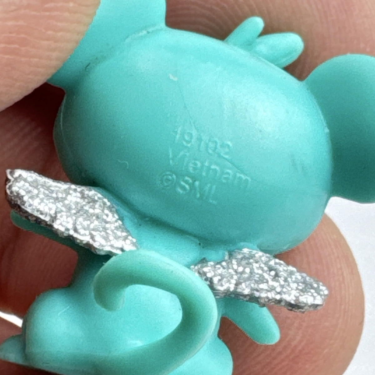 Spin Master Hatchimals CollEGGtibles mini figure in teal and lime green with silver glitter wings.