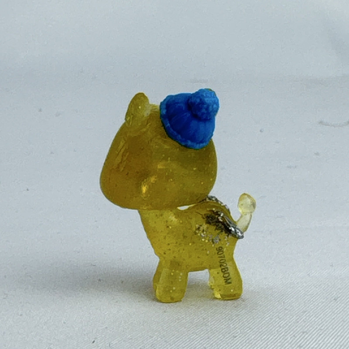 Spin Master Hatchimals CollEGGtibles translucent yellow glitter griffin mini figure wearing a blue winter beanie