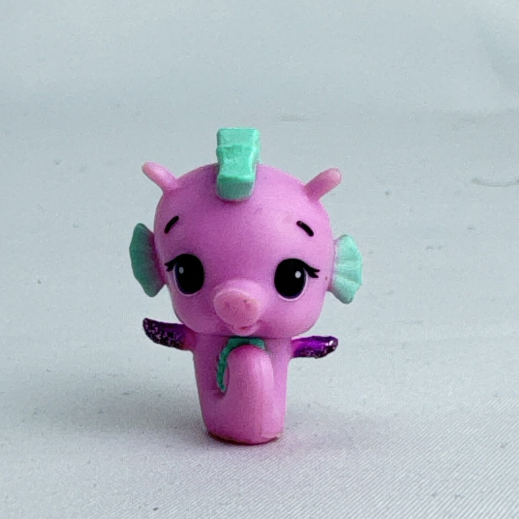 Spin Master Hatchimals Colleggtibles miniature pink seahorse figure with mint green accents and purple glitter wings.