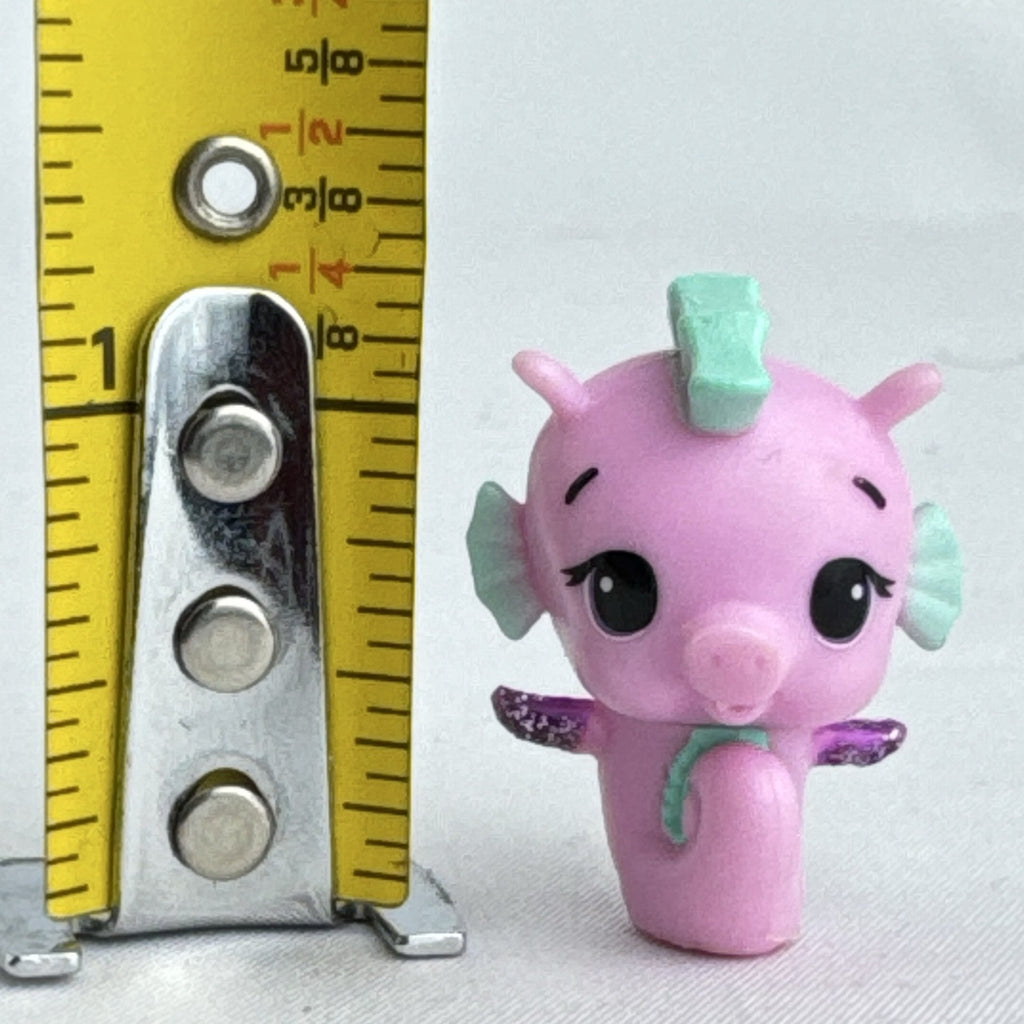 Spin Master Hatchimals Colleggtibles miniature pink seahorse figure with mint green accents and purple glitter wings.