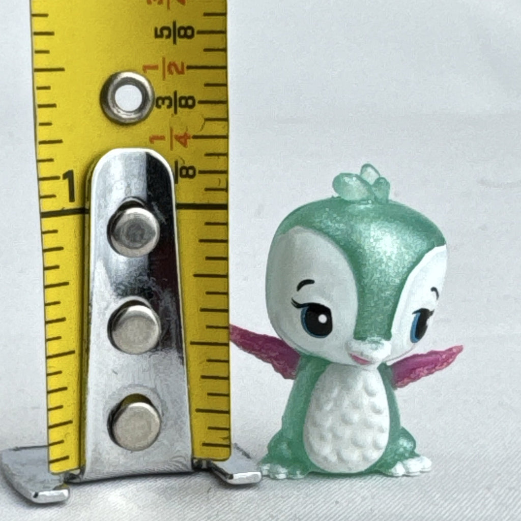 Mattel Barbie Dreamtopia miniature green shimmer penguin pet figure with pink glitter wings.