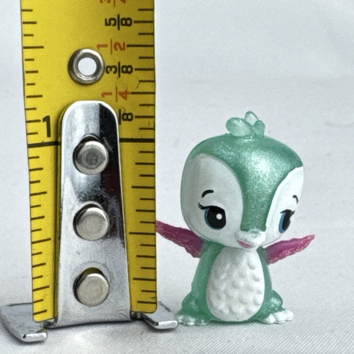Mattel Barbie Dreamtopia miniature green shimmer penguin pet figure with pink glitter wings.