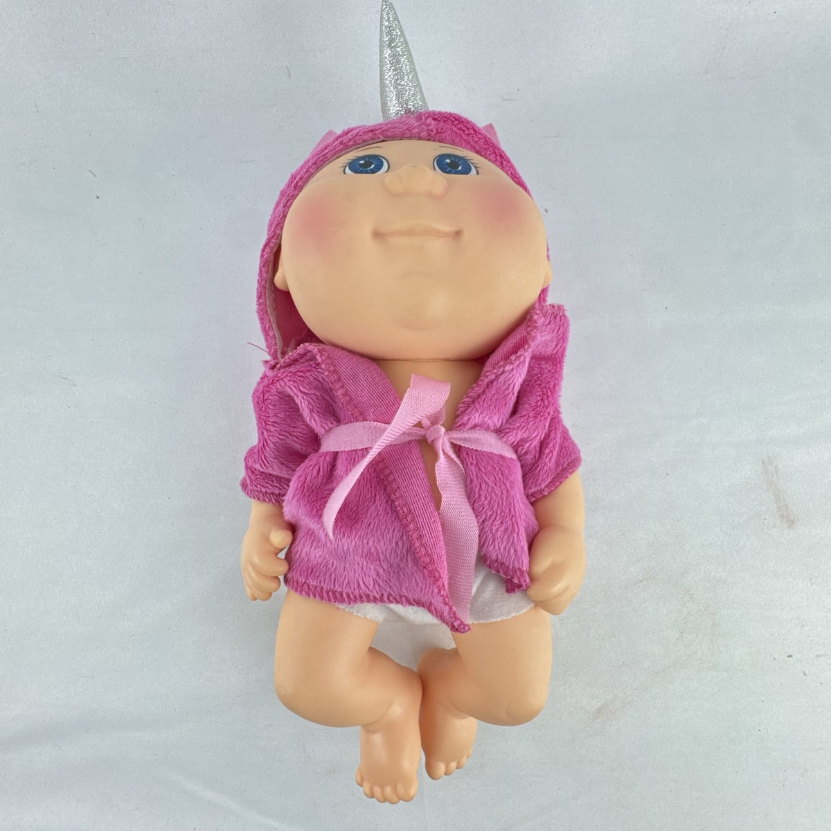 Cabbage Patch Kids 9-inch vinyl baby doll wearing a hooded pink unicorn robe with silver horn
