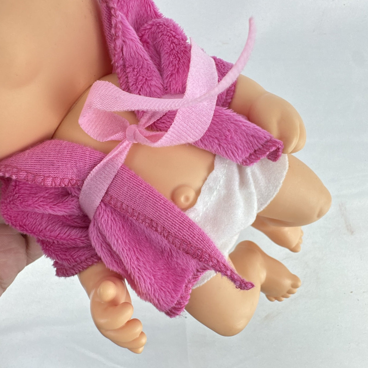 Cabbage Patch Kids 9-inch vinyl baby doll wearing a hooded pink unicorn robe with silver horn