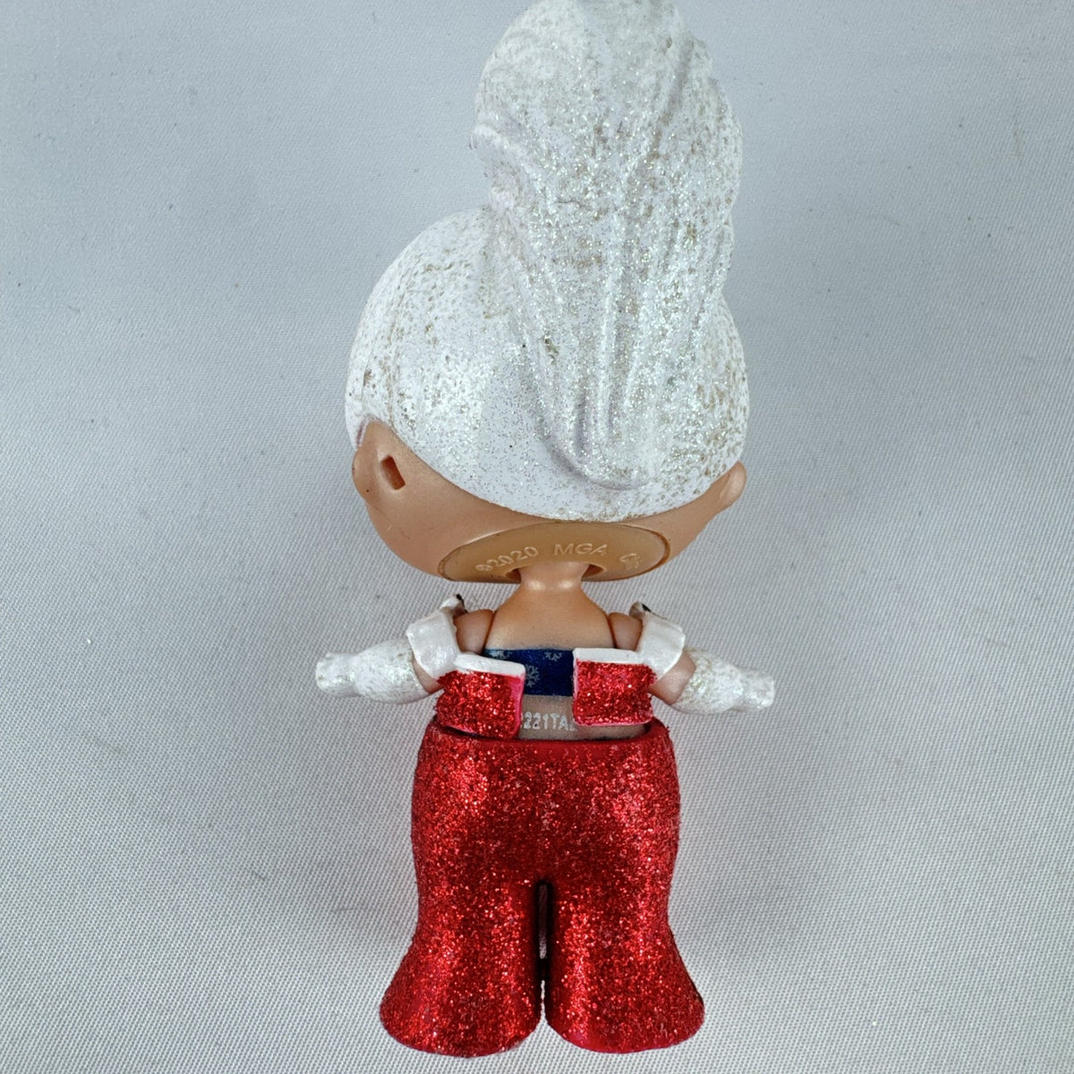 MGA L.O.L. Surprise Holiday Glitter 3-inch mini doll with white glitter hair and red sparkly outfit