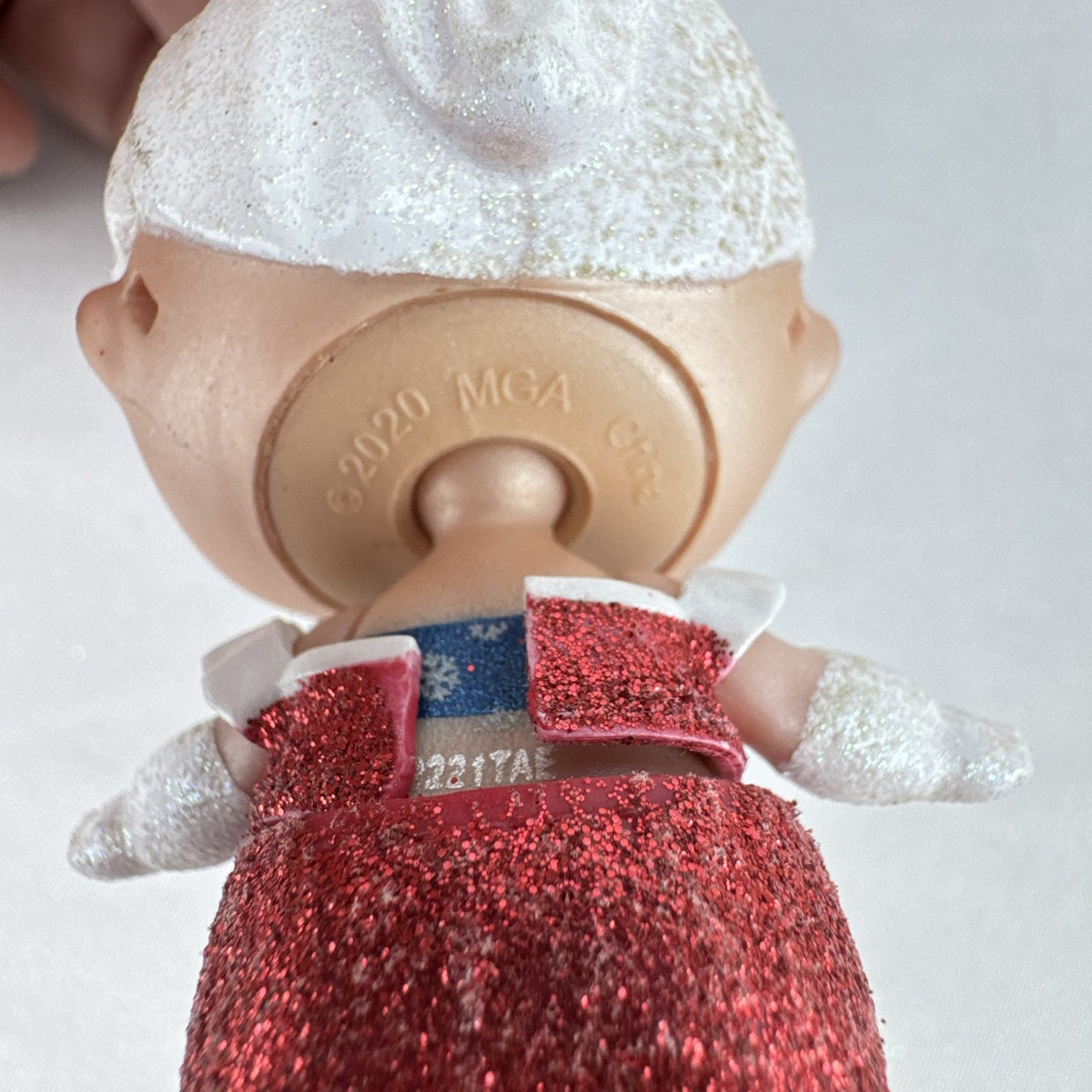 MGA L.O.L. Surprise Holiday Glitter 3-inch mini doll with white glitter hair and red sparkly outfit