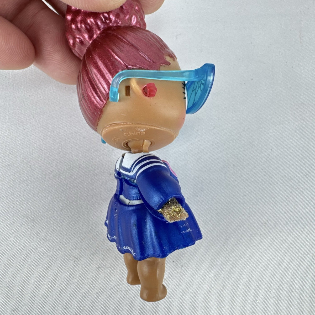 MGA Entertainment L.O.L. Surprise Jet Set Q.T. vinyl doll wearing blue sailor dress and cat-eye sunglasses