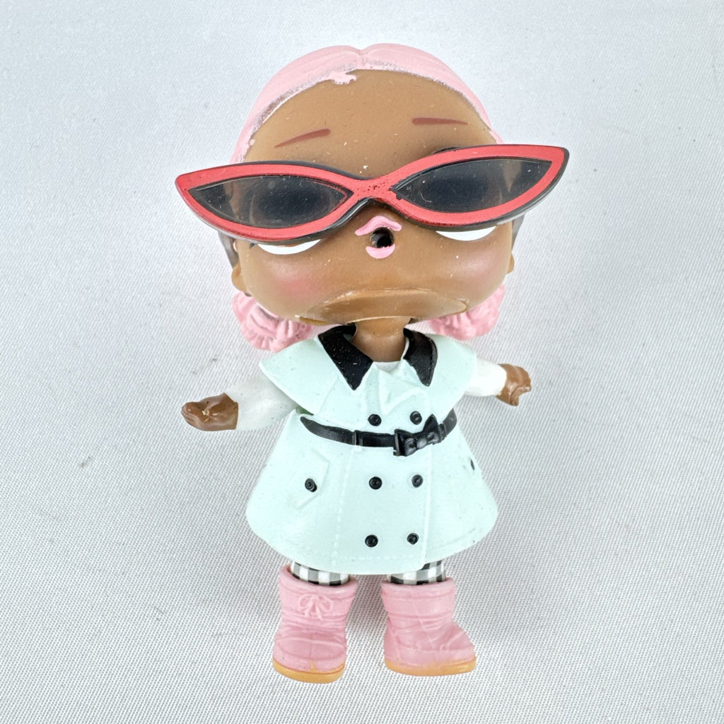 MGA L.O.L. Surprise Jet Set Q.T. 3-inch doll wearing a mint green trench coat, red sunglasses, and pink boots