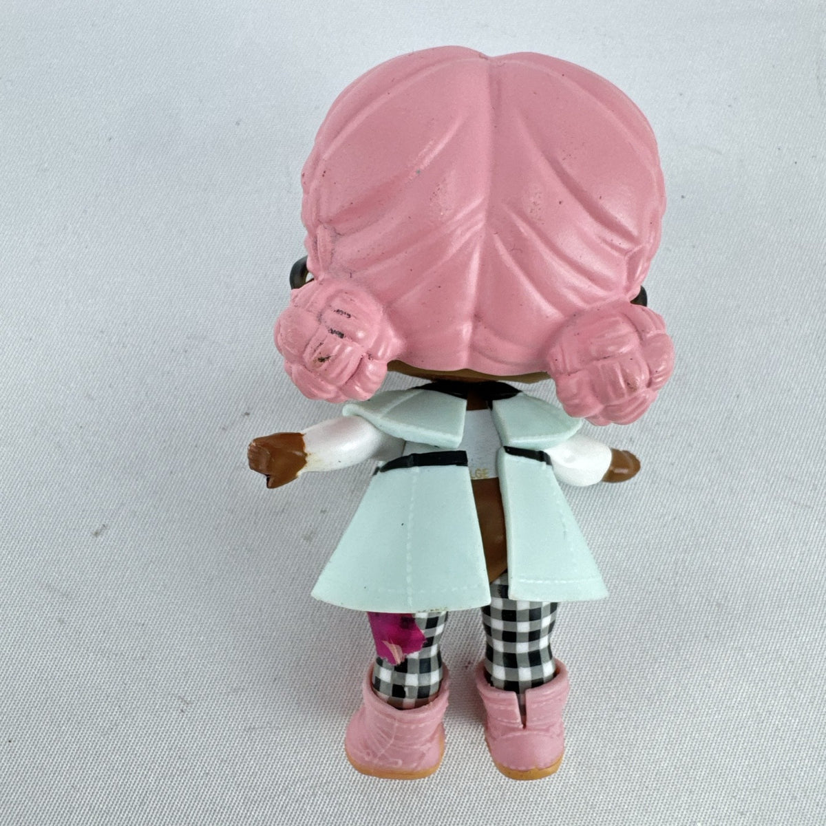 MGA L.O.L. Surprise Jet Set Q.T. 3-inch doll wearing a mint green trench coat, red sunglasses, and pink boots