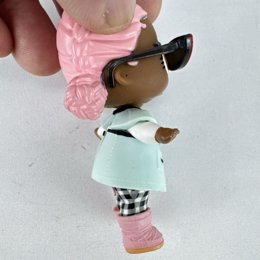 MGA L.O.L. Surprise Jet Set Q.T. 3-inch doll wearing a mint green trench coat, red sunglasses, and pink boots
