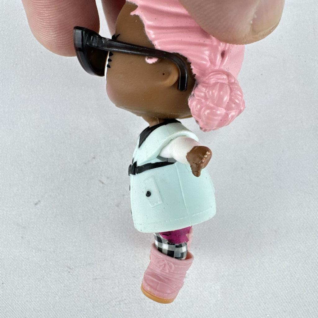 MGA L.O.L. Surprise Jet Set Q.T. 3-inch doll wearing a mint green trench coat, red sunglasses, and pink boots