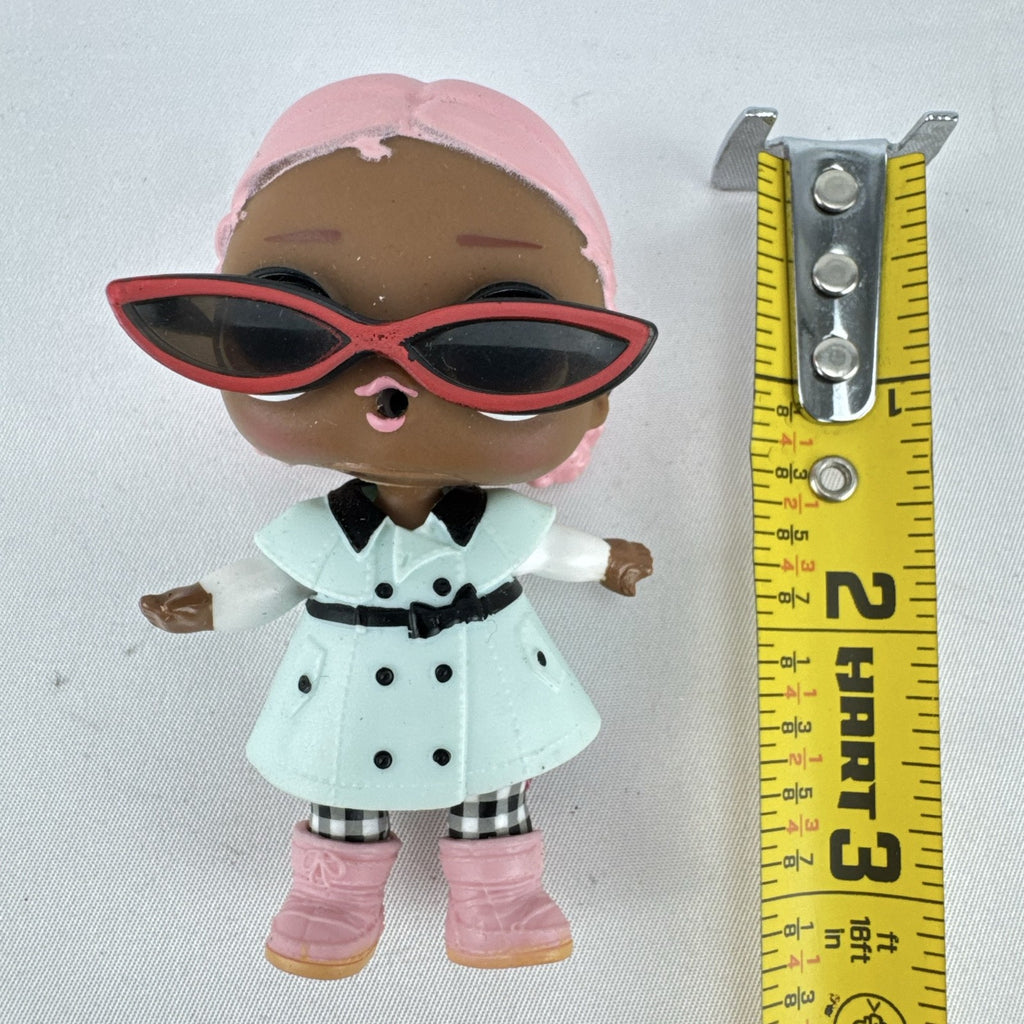 MGA L.O.L. Surprise Jet Set Q.T. 3-inch doll wearing a mint green trench coat, red sunglasses, and pink boots