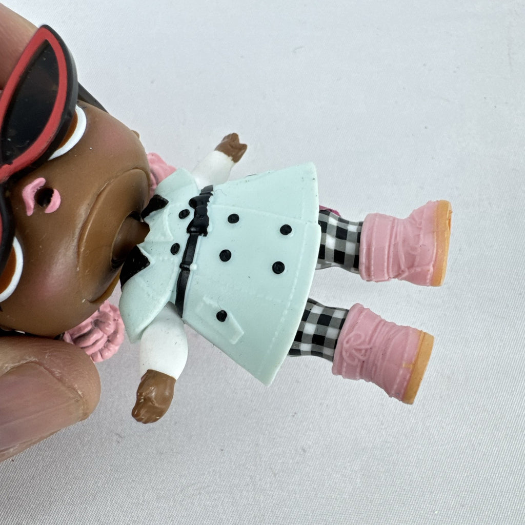 MGA L.O.L. Surprise Jet Set Q.T. 3-inch doll wearing a mint green trench coat, red sunglasses, and pink boots