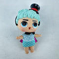 MGA Entertainment L.O.L. Surprise! The Great Baby doll with curly turquoise hair, top hat headband, and black cape.