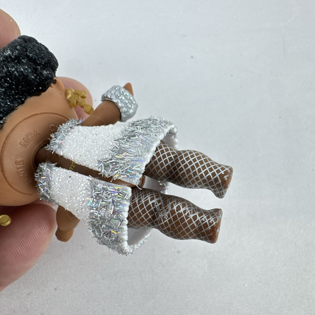MGA L.O.L. Surprise 3-inch doll with black glitter hair buns and silver tinsel dress