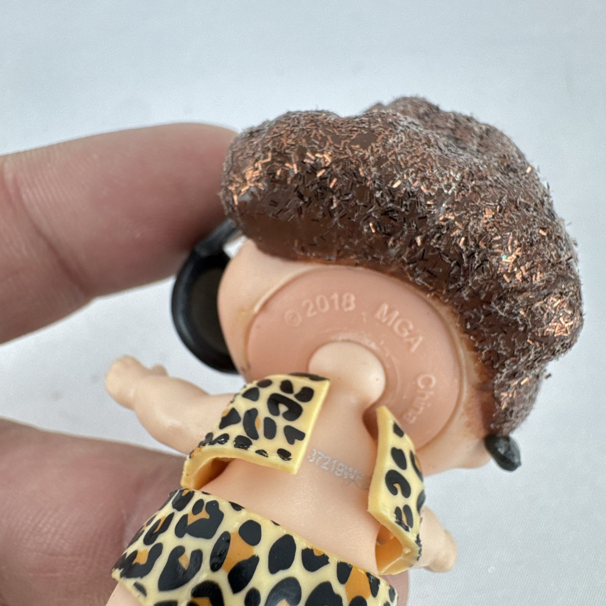 MGA L.O.L. Surprise! 3-inch doll wearing leopard print outfit, cat-eye sunglasses, and boots with brown glitter hair