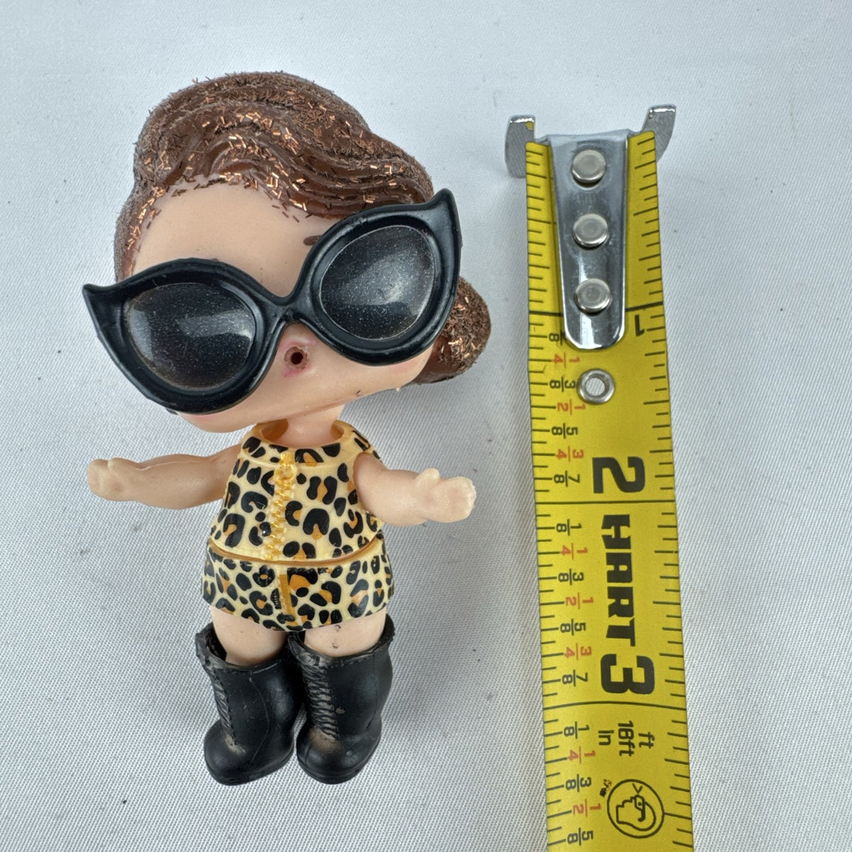 MGA L.O.L. Surprise! 3-inch doll wearing leopard print outfit, cat-eye sunglasses, and boots with brown glitter hair