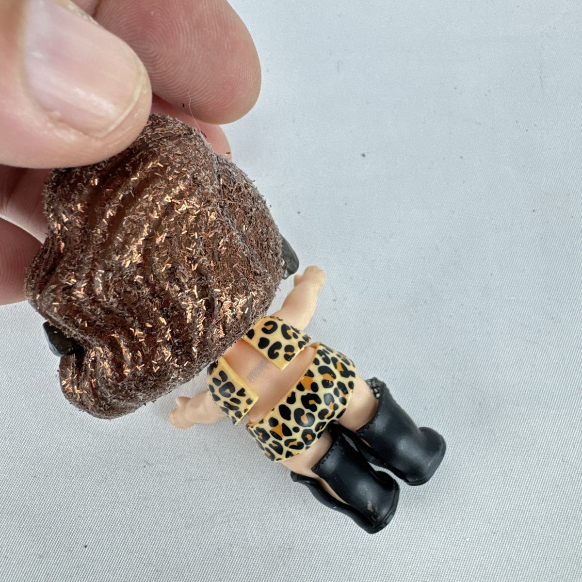 MGA L.O.L. Surprise! 3-inch doll wearing leopard print outfit, cat-eye sunglasses, and boots with brown glitter hair