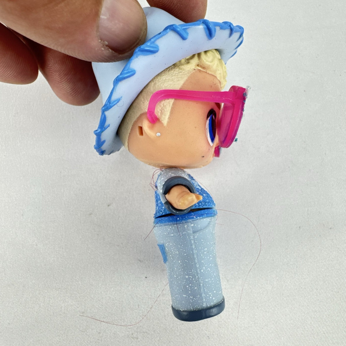 MGA L.O.L. Surprise! Boys Series 1 Do-Si-Dude 3-inch doll wearing blue cowboy hat and pink sunglasses