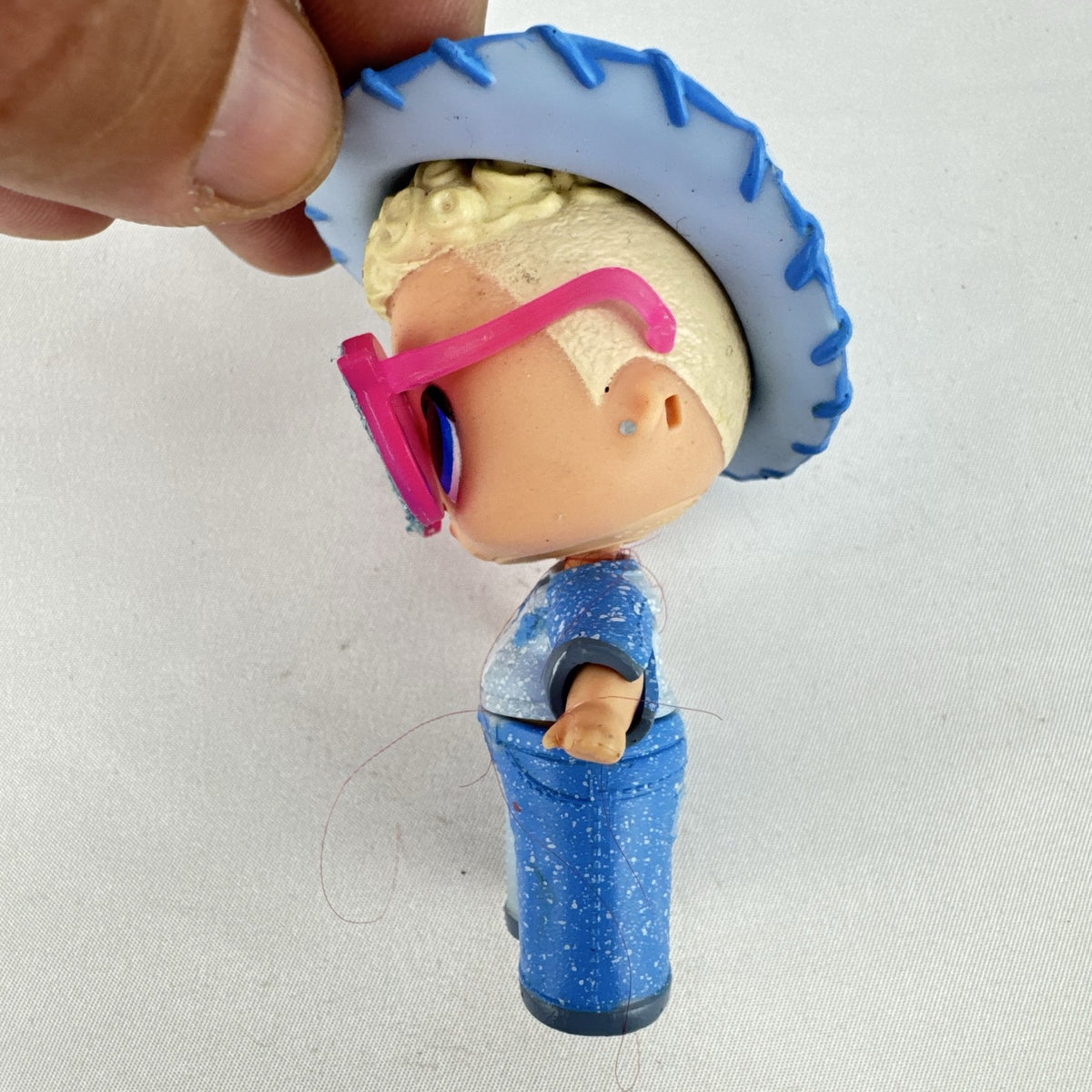 MGA L.O.L. Surprise! Boys Series 1 Do-Si-Dude 3-inch doll wearing blue cowboy hat and pink sunglasses