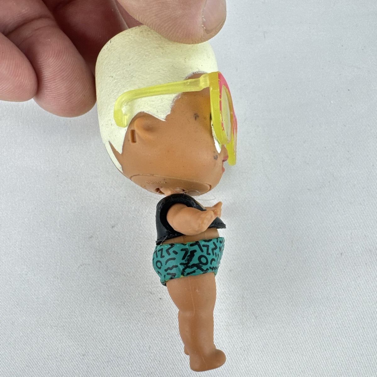 MGA Entertainment L.O.L. Surprise! 3-inch mini doll with blonde flat-top hair, sunglasses, and BAD crop top