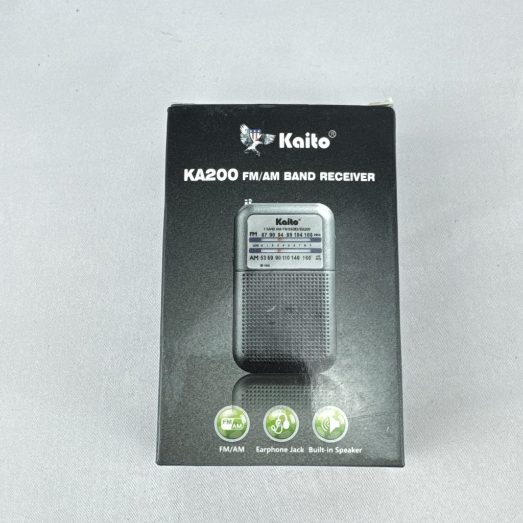Gray Kaito KA200 pocket AM FM radio with analog dial and headphone jack in original packaging