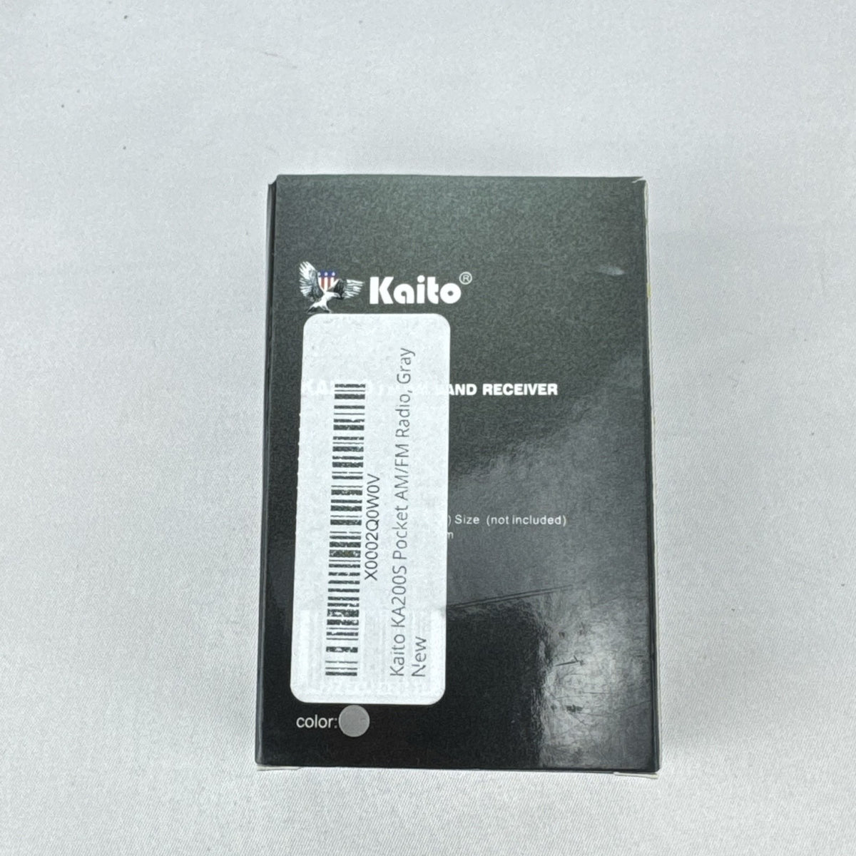 Gray Kaito KA200 pocket AM FM radio with analog dial and headphone jack in original packaging