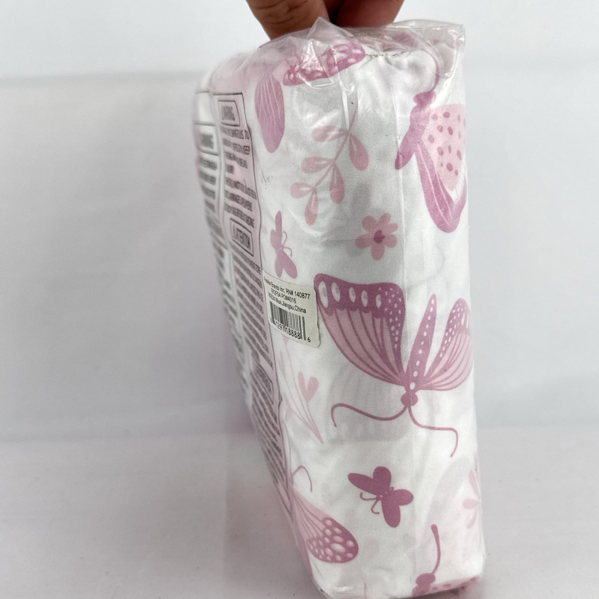 The Peanutshell 4-pack microfiber fitted crib sheets in pink floral and butterfly patterns, factory sealed packaging.