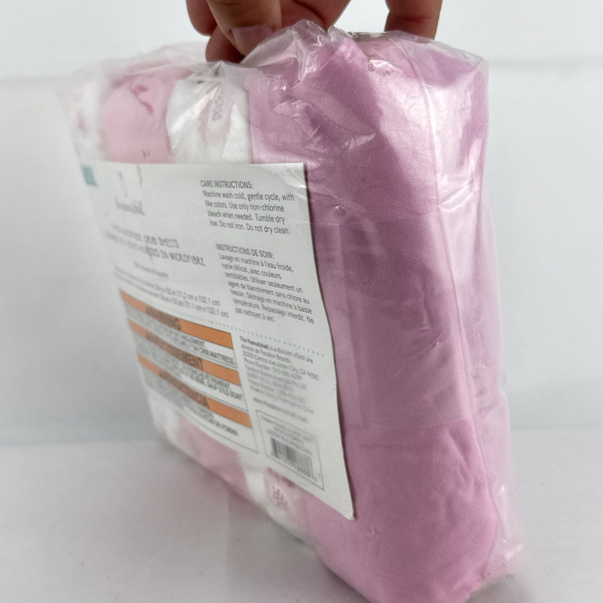 The Peanutshell 4-pack microfiber fitted crib sheets in pink floral and butterfly patterns, factory sealed packaging.