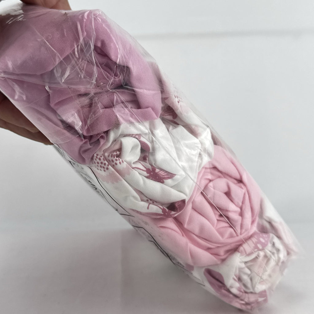 The Peanutshell 4-pack microfiber fitted crib sheets in pink floral and butterfly patterns, factory sealed packaging.