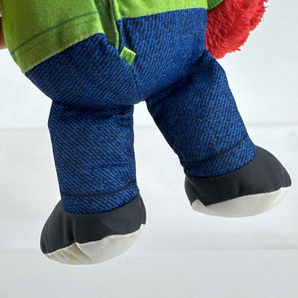 Hasbro Sesame Street ABC Elmo 12-inch plush toy wearing a colorblock alphabet shirt and sneakers.