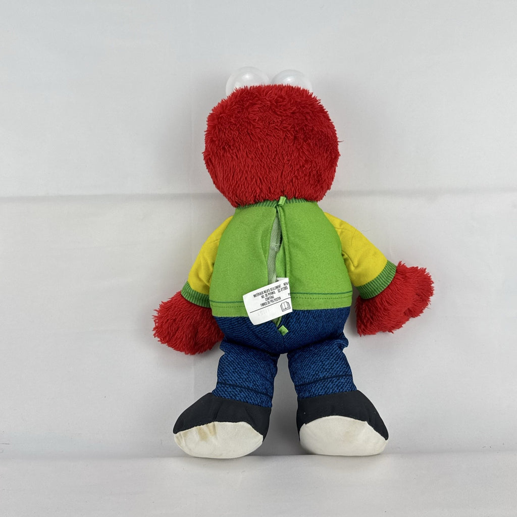 Hasbro Sesame Street ABC Elmo 12-inch plush toy wearing a colorblock alphabet shirt and sneakers.