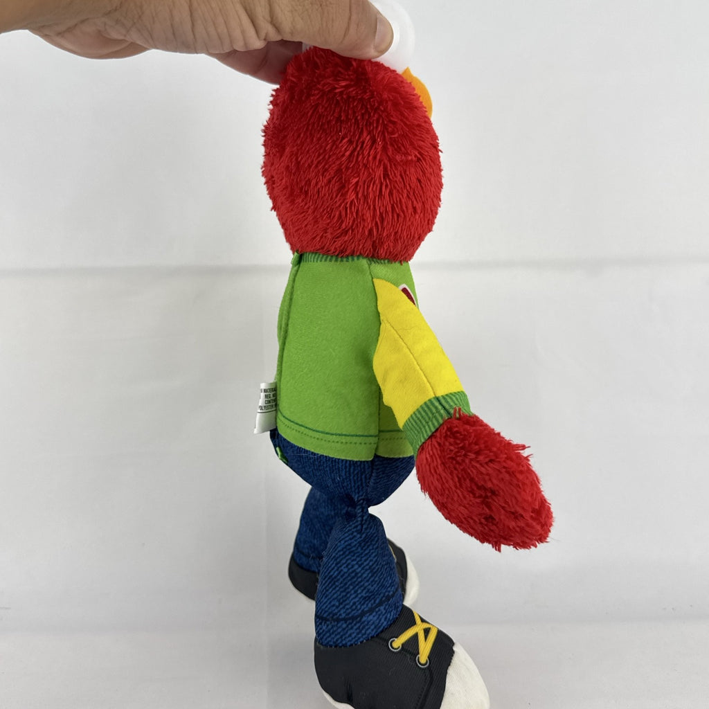 Hasbro Sesame Street ABC Elmo 12-inch plush toy wearing a colorblock alphabet shirt and sneakers.