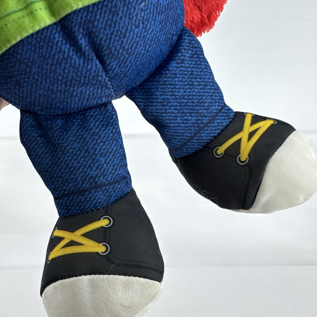 Hasbro Sesame Street ABC Elmo 12-inch plush toy wearing a colorblock alphabet shirt and sneakers.
