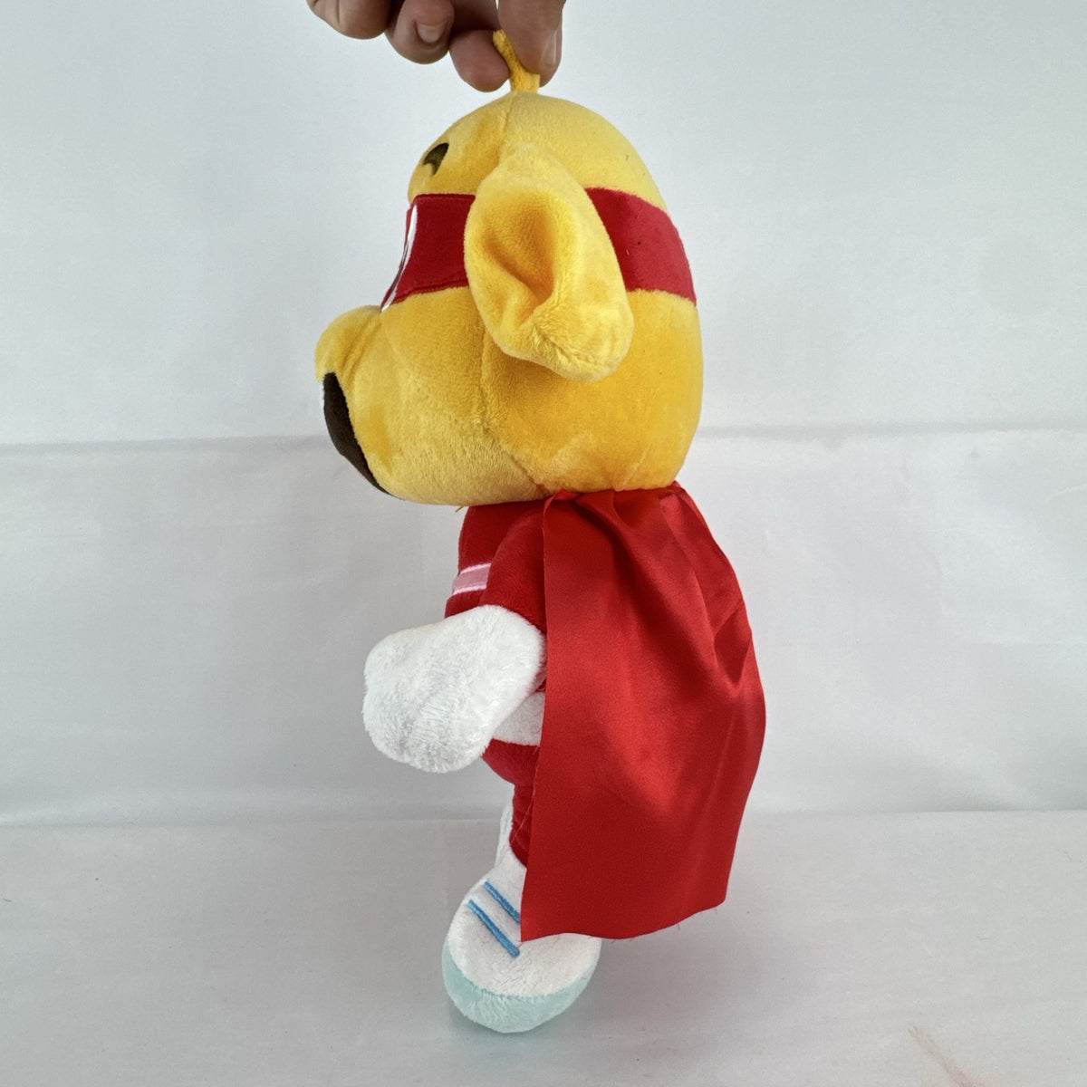 Kiddopia 12-inch yellow superhero dog plush toy wearing a red satin cape and embroidered eye mask.
