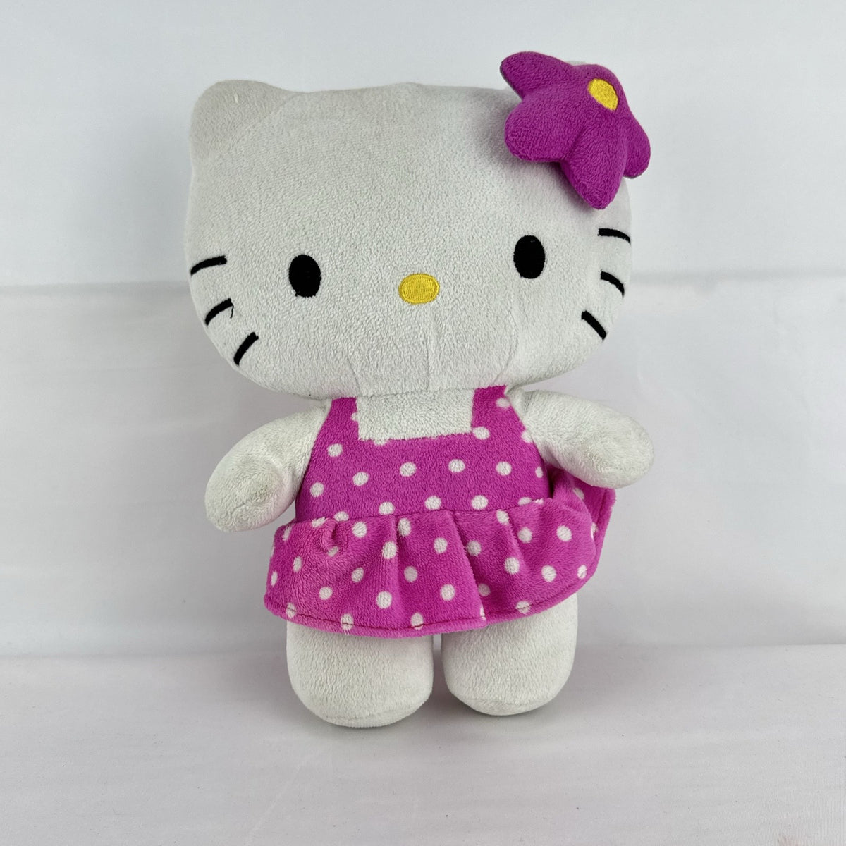 Sanrio 11-inch Hello Kitty plush wearing a pink polka dot dress with a purple flower