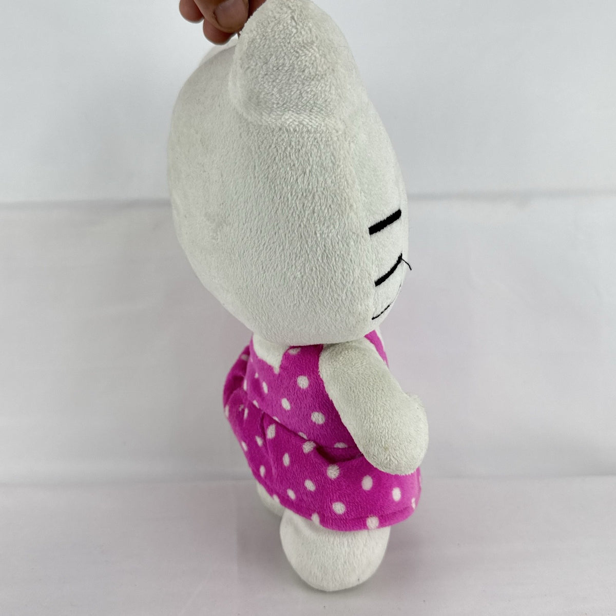 Sanrio 11-inch Hello Kitty plush wearing a pink polka dot dress with a purple flower