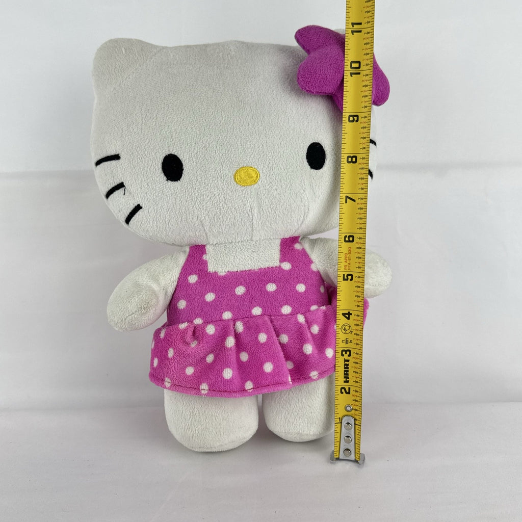 Sanrio 11-inch Hello Kitty plush wearing a pink polka dot dress with a purple flower