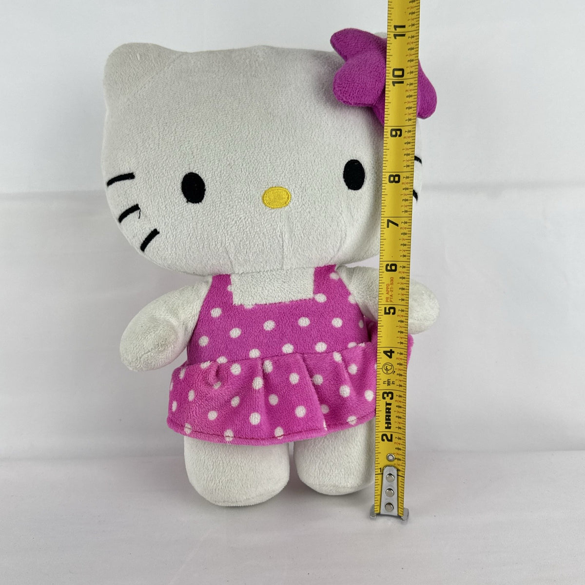 Sanrio 11-inch Hello Kitty plush wearing a pink polka dot dress with a purple flower