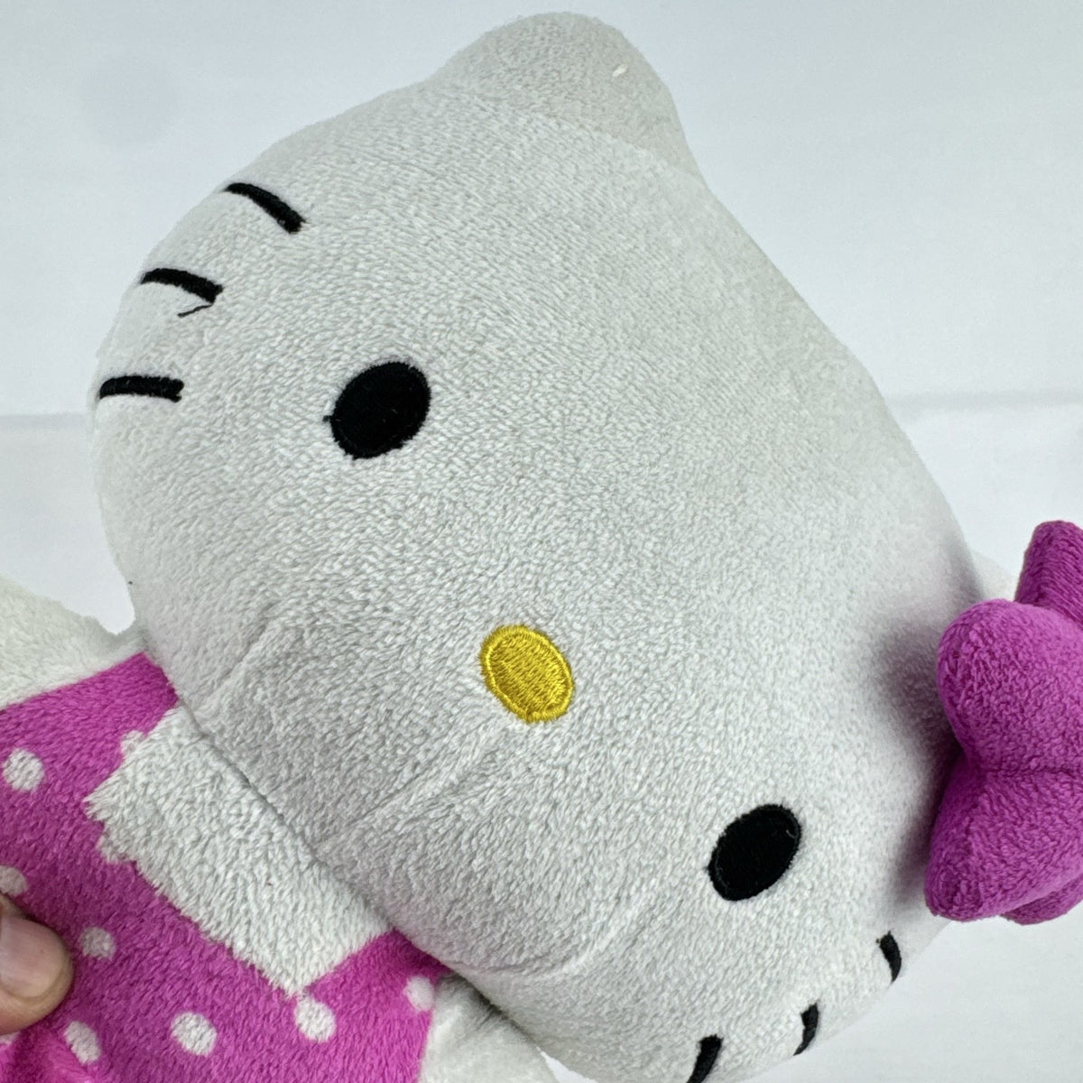Sanrio 11-inch Hello Kitty plush wearing a pink polka dot dress with a purple flower